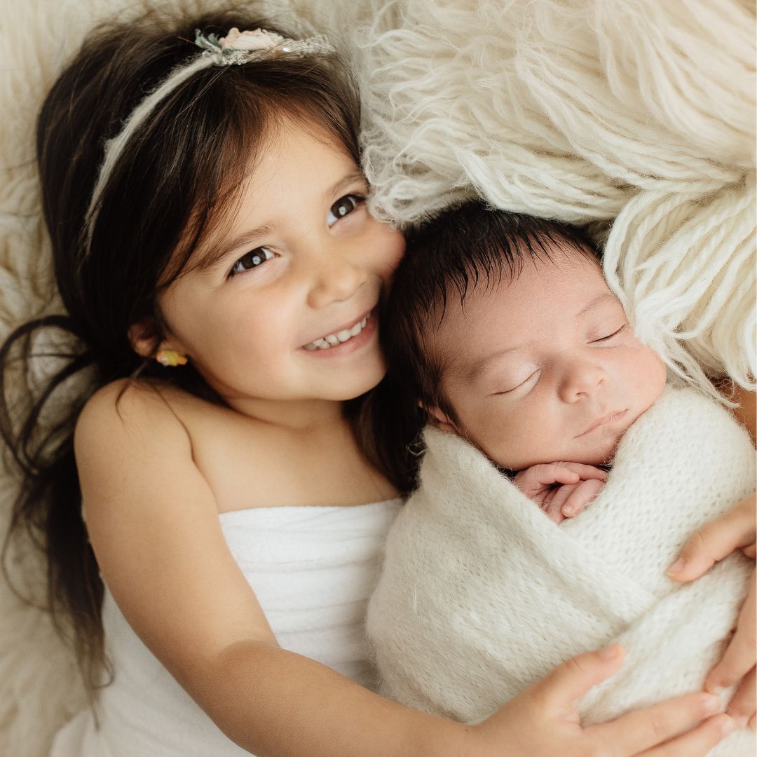 toddler holding her little sister