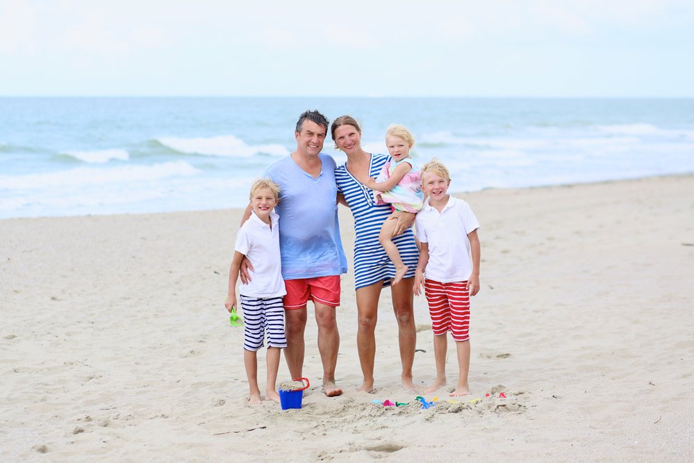 maegan testimonial mom and dad with twin boys and a daughter on the beach in the summer