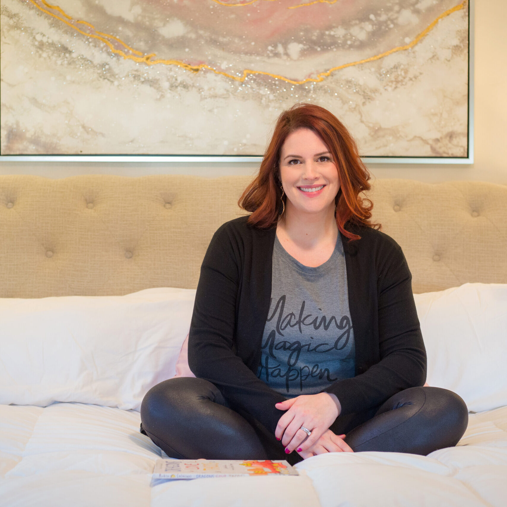 christine brown, founder of bella luna family, sitting on a bed